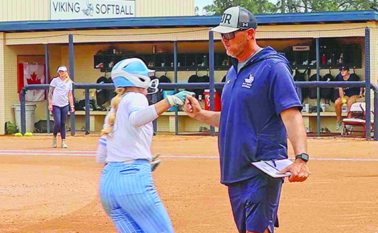 Caylee Elder, here congratulated by coach Joe Pound after hitting a home run against Pasco-Herando, hit three home runs in tournament play in Alabama in three games. (RITA FULLERTON / Special to the Daily News)