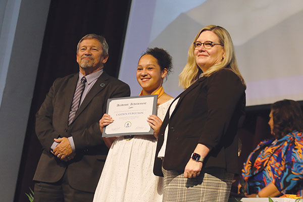 SARAH CAVACINI/Palatka Daily News – Q.I. Roberts Junior-Senior High School student Cayden Ferguson, center, takes a photo with Superintendent Rick Surrency, left, and Palatka Daily News Publisher Jennifer Moates after receiving a Top Scholar award Tuesday.
