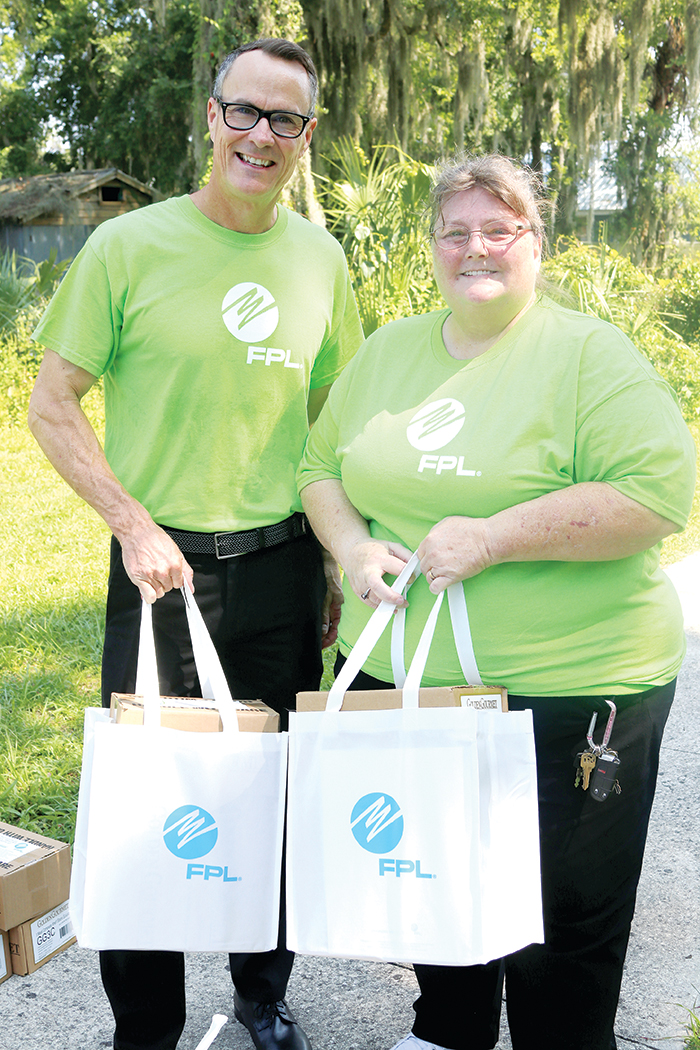Sean Helton, left, a Florida Power & Light representative, and Jackie Snyder of the Suwannee River Economic Council in Palatka hold two of the hurricane meal kits that were distributed to local senior citizens. 