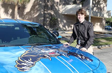 Curtis Moore stands next to the car for which he designed the exterior art.