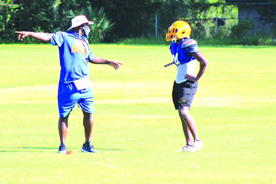 Palatka High School football coach Willie Fells shows Kamari Cohens where to go on kickoff coverage during Wednesday’s practice. (MARK BLUMENTHAL / Palatka Daily News)