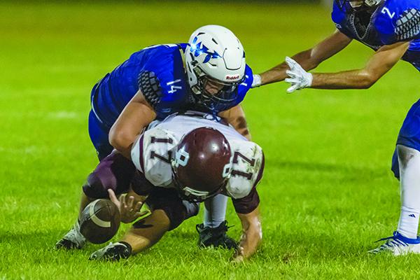 Peniel Baptist Academy’s Aiden Sullivan (14) wraps up an Old Plank receiver, forcing an incompletion in a game played last September at Theobold Sports Complex. (Daily News file photo)