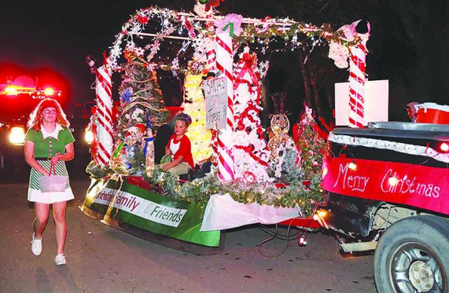 Participants in last year’s Christmas parade in Interlachen hand out candy. The town plans stationary parade floats this year and fireworks as part of its Christmas celebration.