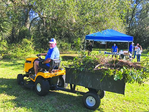 Volunteer Bob Nelson picks up brush Saturday to help clean up the Water Works Environmental Education Center in Palatka.