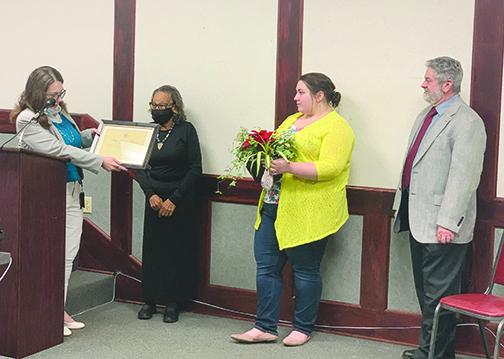 Palatka Vice Mayor Mary Lawson Brown receives a plaque and flowers from city employees at Thursday’s Palatka City Commission meeting weeks before she retires after 36 years in office.