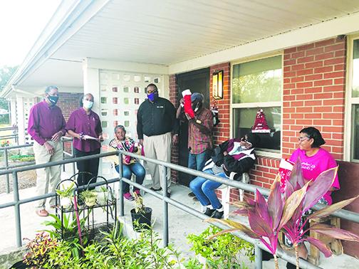 Palatka Housing Authority staff members greet seniors, to whom they passed out stockings earlier this week.
