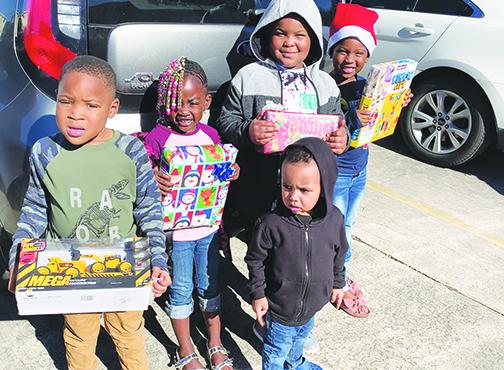 Jahvire Honor, Derrikay McDuffie, Kayden Nelson, Raheme Betts Jr. and Jahzaiya Honor hold toys they received from the Palatka Housing Authority’s toy giveaway.