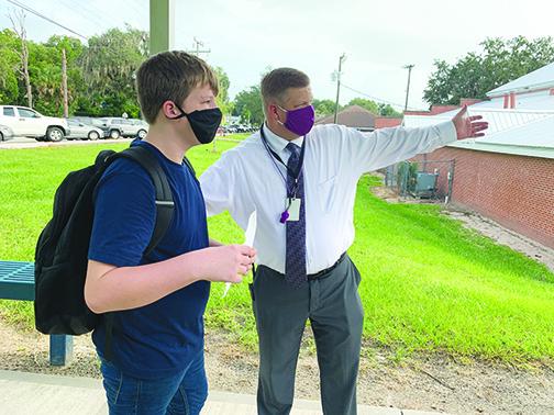 Miller Middle School’s principal shows a student to his class on the first day of school, which was postponed for two weeks in August because of COVID-19.