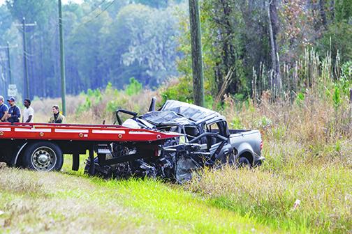 A crushed pickup truck on the side of State Road 100 is loaded onto a tow truck Wednesday after its driver collided with a tractor-trailer that morning.
