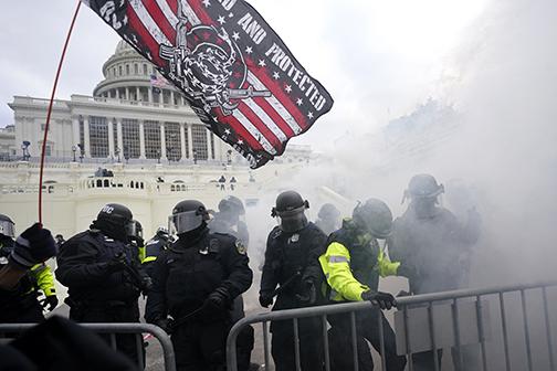 Police hold off President Donald Trump supporters who tried to break through a police barrier Wednesday at the Capitol in Washington. As Congress prepared to affirm President-elect Joe Biden’s victory, thousands of people gathered to show their support for Trump and his claims of election fraud.