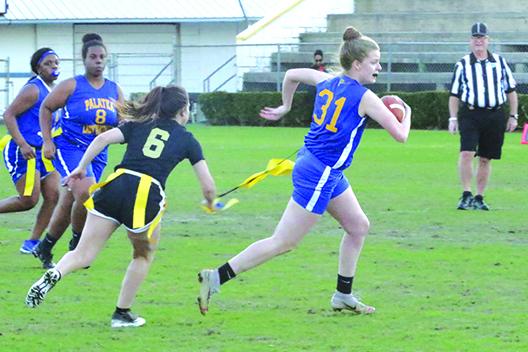 Palatka’s Mattie Smith has her flag pulled by an unidentified St. Augustine player. (ANTHONY RICHARDS / Palatka Daily News)