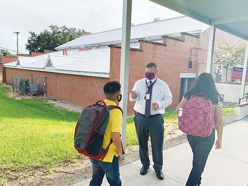 Miller Middle School Principal Tim Adams checks students’ temperatures during the first day of the 2020-2021 school year.