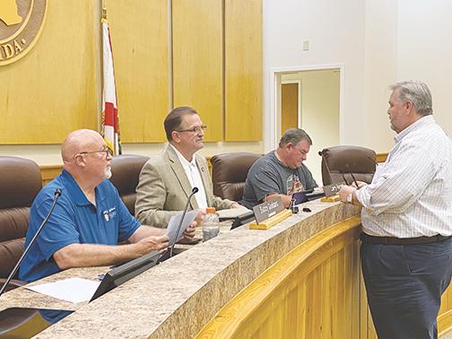 From left, then-County Commissioner Buddy Goddard, Commissioners Larry Harvey and Jeff Rawls, and County Administrator Terry Suggs discuss upcoming COVID-19 protocols during an emergency meeting in March 2020.