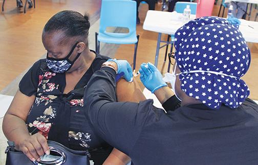 Palatka resident Gwendolyn Junior, 59, receives the COVID-19 vaccination Friday at SJR State.