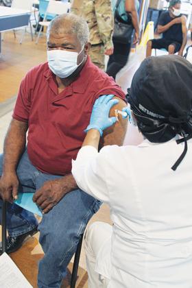 San Mateo resident Virgil Baynard, 62, receives the COVID-19 vaccination Friday at SJR State.