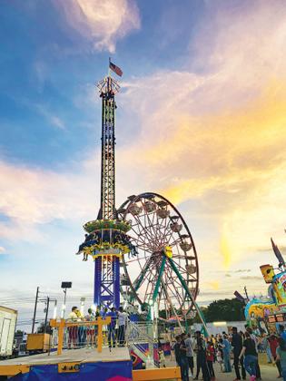 People at the Putnam County Fair ride the Ferris wheel and drop tower Saturday, the last night of the fair.