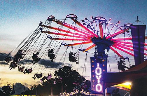 Laughter and screams can be heard Saturday as people ride the flying swings at the fair.