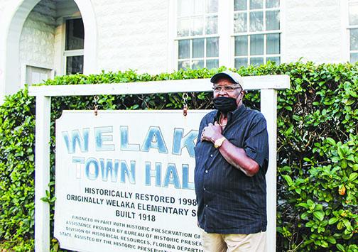 Willie Washington stands near a sign in front of Welaka Town Hall in February. The longtime town councilman died earlier this month.