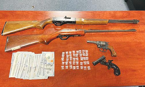 Guns, cash and drugs were found when officers and deputies conducted a raid Thursday morning, authorities said.