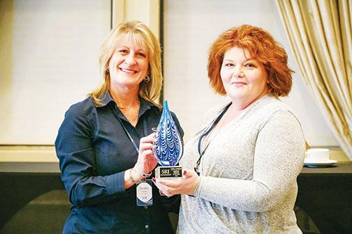 Shelley Kaiser, left, chief operating officer for SRI Management, presents Angela Wynkoop, executive director of Vintage Care Senior Living in Palatka, with the company’s 2020 Executive Director of the Year award earlier this year.