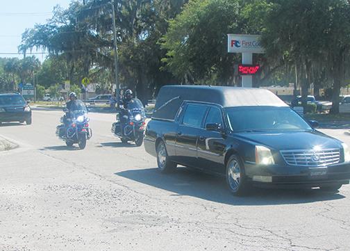 The procession for Putnam County Sheriff’s Office Capt. Mark Elam pulls away from Johnson-Overturf Funeral Home on Monday afternoon.