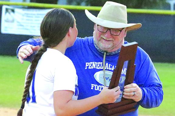 Paige Bryan, the only senior on the Peniel Baptist Academy softball team, receives a hug and the District 4-2A championship trophy from Peniel Baptist athletic director Terry Goodwin. (ANTHONY RICHARDS / Palatka Daily News)