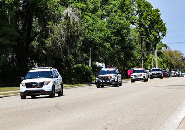 Law enforcement vehicles escort the body of Mark Elam along Palm Avenue to Johnson-Overturf Funeral Home in Palatka on Thursday afternoon.