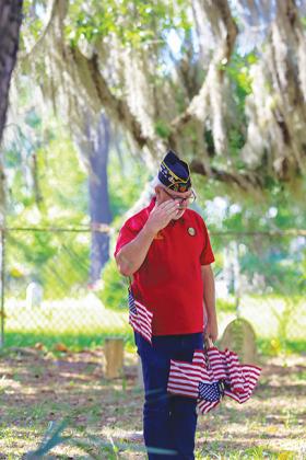 American Legion Commander Ken Moore on Tuesday salutes the grave of a veteran who is buried at West View Cemetery in Palatka.