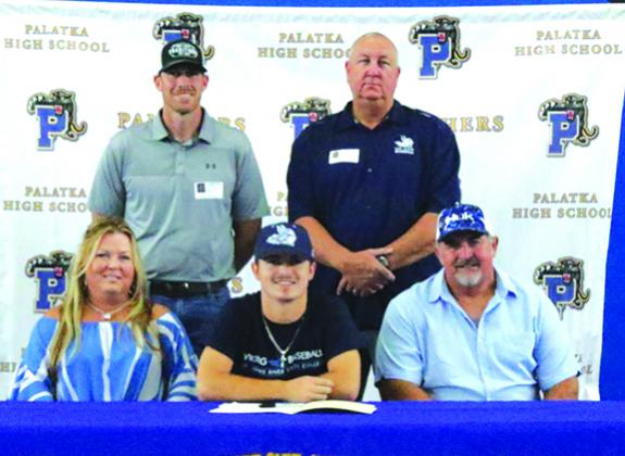 Palatka High’s Layton DeLoach is all smiles after signing his letter of intent to play baseball and attend classes at St. Johns River State College next year. Flanking DeLoach are his mother, Dana, and father, Mike. Standing, from left, are PHS baseball coach Alan Rick and SJR State baseball coach and athletic director Ross Jones. (ANTHONY RICHARDS / Palatka Daily News)