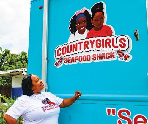 Country Girl’s Seafood Shack owner Stephanie Curry looks up at her food truck logo, which was inspired by her granddaughters.
