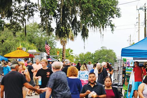 Despite some afternoon rain showers during Crescent City’s Red, White & Boom event, crowds of people stay to shop from local vendors and watch the fireworks.