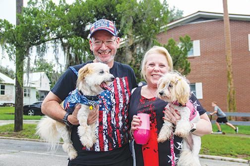 Pomona Park residents Harlin and Sandra Silvers attend the Red, White and Boom celebration Saturday decked out in patriotic outfits with their dogs.