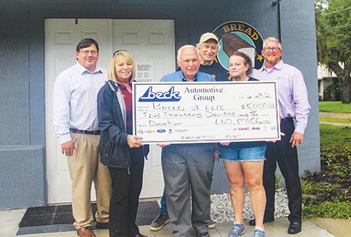 Wayne McClain, vice president of Beck Automotive Group, smiles Tuesday with Bread of Life board members Theresa Odom, Cliff Lyda and Kim Daley as well as Beck general managers Jeremy Alexander and Matt Buckles after presenting a check for $5,000 to the nonprofit organization. 