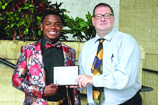 Palatka three-sport standout Delton Nealy Jr. receives his Daily News Senior Male Athlete of the Year plaque from sports editor Mark Blumenthal. (ANTHONY RICHARDS / Palatka Daily News)