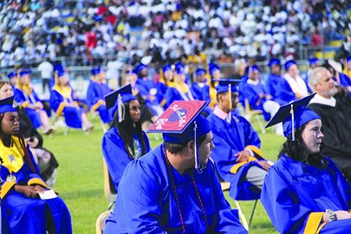 A Palatka High School graduate with “That’s All Folks” displayed on his cap waits with his classmates for the graduation ceremony to begin.