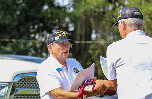 Sergeant-at-Arms Gary Coward hands Second Vice Commander Kevin Tracey the American flags deemed unserviceable and ready to be retired Monday at American Legion Bert Hodge Post 45.