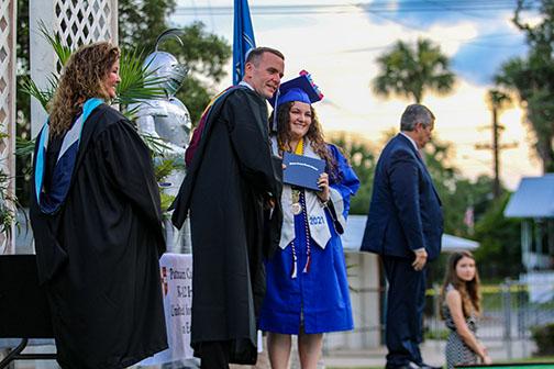 Q.I. Roberts graduate Brenna Carmichael smiles with Principal Joe Theobold after receiving her diploma Saturday.