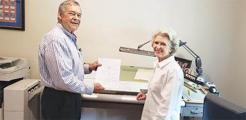 Robert and Dianne Taylor look over a plan at their home office.