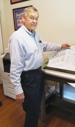Architect Robert Taylor looks over a plan at his home office.
