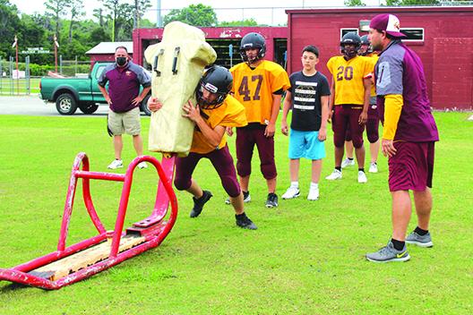 Crescent City head football coach Sean Delaney (in back) and assistant coach/athletic director Tim Ross watch players go through a blocking drill during spring practice in May. (MARK BLUMENTHAL / Palatka Daily News)