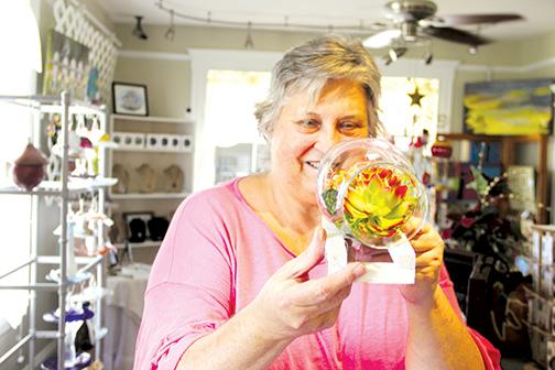 Debra Broome, a Palatka Art League member, shows the centerpiece she made with artificial succulents.