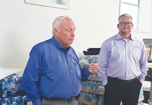 Wayne McClain, left, vice president for Beck Automotive Group, talks at Bread of Life last month before presenting a $5,000 donation to the organization from Beck. 
