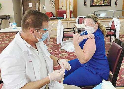 A medical official gives a COVID vaccine at Solaris HealthCare in Palatka earlier this year.