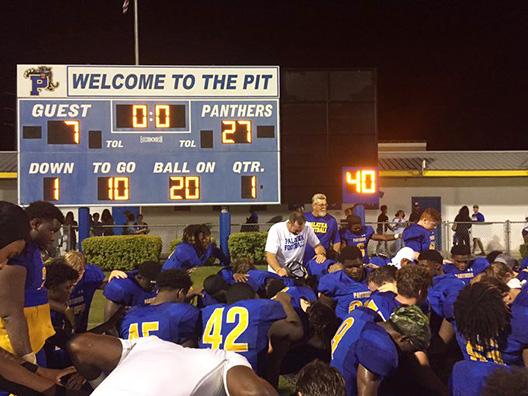 Palatka football coach Patrick Turner (middle) celebrates with his team after claiming its first victory of the season against Weeki Wachee, 27-7. (COREY DAVIS / Palatka Daily News)