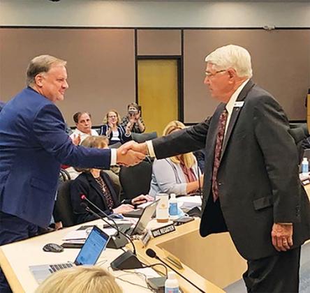 St. Johns River Water Management District Governing Board Chairman Douglas Burnett, right, congratulates Mike Register after Register was appointed as the district’s new executive director Tuesday. 