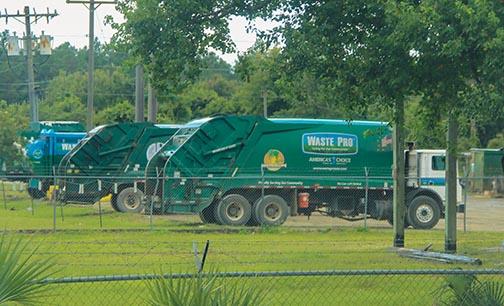 Waste Pro garbage collection trucks remain stationary Wednesday at the company’s facility in Palatka.