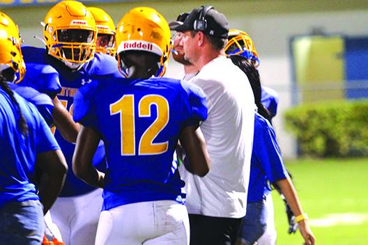 New Palatka coach Patrick Turner talks to quarterback Jamarrie McKinnon (12) and his offensive teammates during the preseason matchup on Aug. 27 at home against Yulee. (MARK BLUMENTHAL / Palatka Daily News)