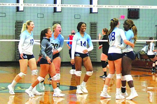 Vikings players celebrate a first-set kill by Kendall Hatchett (right) against Lake-Sumter. (MARK BLUMENTHAL / Palatka Daily News)