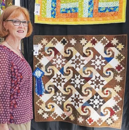Sandra Black of Palatka stands next to her prize-winning quilt, Snails Trail, at the eighth annual Quilts by the River show at Miss D’s Quilts in Palatka on Friday morning.