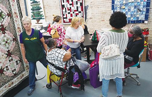 Contestants and spectators of the eighth annual Mss D’s Quilts By the River make their way around the store this weekend before the winners are announced.